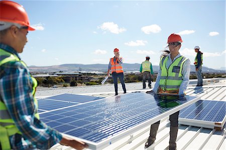 simsearch:6108-06168107,k - Engineers lifting solar panel at sunny power plant Stock Photo - Premium Royalty-Free, Code: 6113-09157816