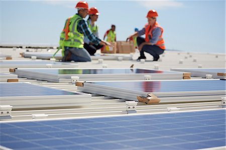 simsearch:6108-06168107,k - Engineers installing solar panels at sunny power plant Stock Photo - Premium Royalty-Free, Code: 6113-09157818