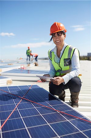simsearch:6113-07160283,k - Portrait confident, smiling female engineer with digital tablet examining solar panels at power plant Stock Photo - Premium Royalty-Free, Code: 6113-09157839