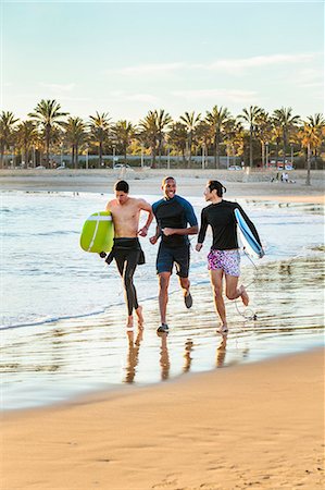 simsearch:6113-06899255,k - Enthusiastic male surfers running with surfboards on ocean beach Stock Photo - Premium Royalty-Free, Code: 6113-09168363
