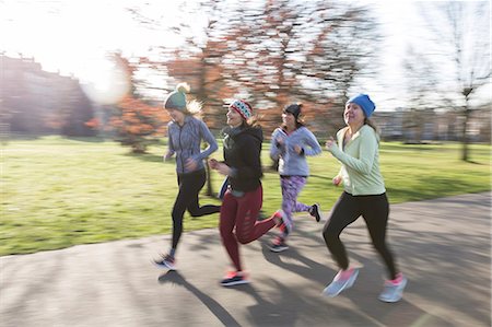 simsearch:628-05817723,k - Smiling female runners running in sunny park Stock Photo - Premium Royalty-Free, Code: 6113-09168325