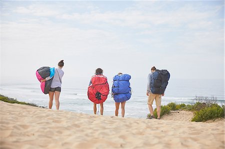 simsearch:6113-07542497,k - Paragliders carrying parachute backpacks on ocean beach Stock Photo - Premium Royalty-Free, Code: 6113-09168453