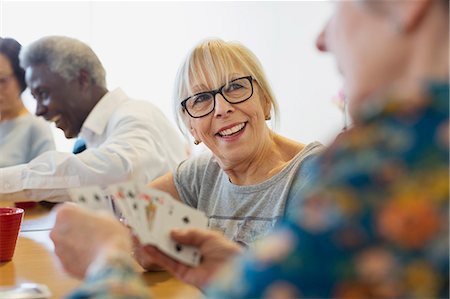 playing cards - Smiling senior woman playing cards with friend in community center Stock Photo - Premium Royalty-Free, Code: 6113-09168407