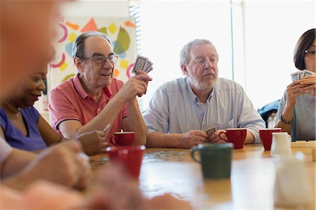 Senior friends playing cards and drinking tea in community center Stock Photo - Premium Royalty-Free, Code: 6113-09168429