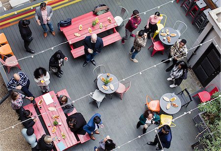 pleasure business - Overhead view friends socializing, drinking and eating at party on patio Stock Photo - Premium Royalty-Free, Code: 6113-09168593