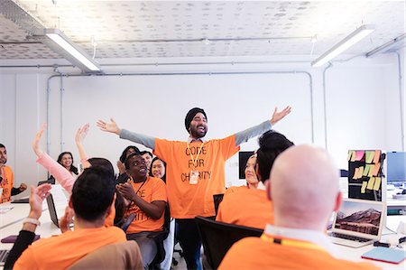 Exuberant hackers cheering, coding for charity at hackathon Stock Photo - Premium Royalty-Free, Code: 6113-09168669