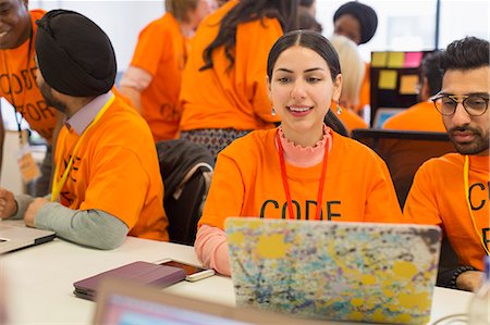 Hackers at laptop coding for charity at hackathon Stock Photo - Premium Royalty-Free, Code: 6113-09168675