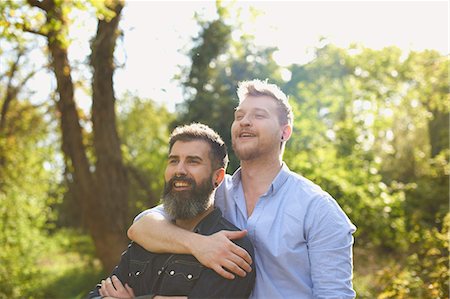 simsearch:614-08148673,k - Affectionate male gay couple hugging in sunny park Stock Photo - Premium Royalty-Free, Code: 6113-09168884