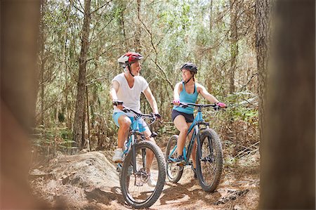 enjoying life outdoor mature family - Father and daughter mountain biking on trail in woods Stock Photo - Premium Royalty-Free, Code: 6113-09168827