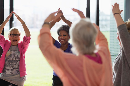 simsearch:853-03616708,k - Happy active senior women exercising, stretching arms overhead in exercise class Stock Photo - Premium Royalty-Free, Code: 6113-09178623
