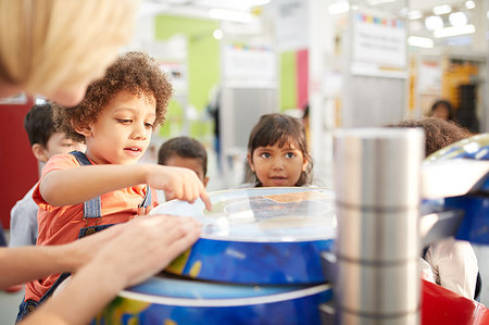 Curious kids at interactive exhibit in science center Foto de stock - Sin royalties Premium, Código: 6113-09178893