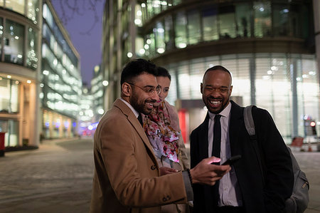 foreground (something in the foreground) - Business people using smart phone on urban street at night Stock Photo - Premium Royalty-Free, Code: 6113-09178826