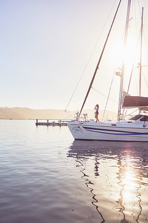 Woman standing on sunny boat in harbor Photographie de stock - Premium Libres de Droits, Code: 6113-09178980