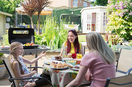 family lunches in the backyard - Lesbian couple and daughter enjoying barbecue lunch on summer patio Stock Photo - Premium Royalty-Free, Code: 6113-09191928