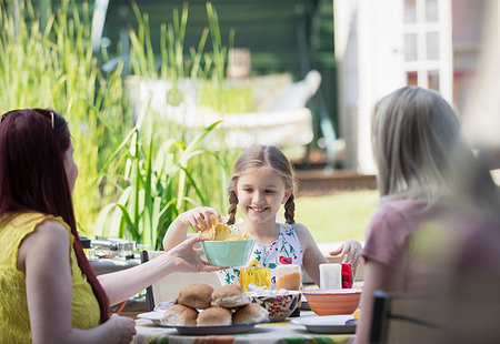 simsearch:6113-07147647,k - Lesbian couple and daughter enjoying lunch on patio Stock Photo - Premium Royalty-Free, Code: 6113-09191935
