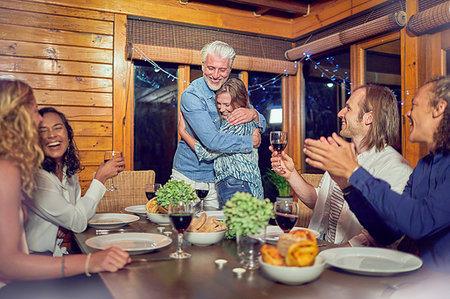 simsearch:6113-07790692,k - Friends clapping for affectionate couple hugging at dinner table Stock Photo - Premium Royalty-Free, Code: 6113-09192092