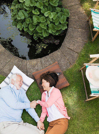 Affectionate senior couple laying by pond in garden Stock Photo - Premium Royalty-Free, Code: 6113-09192016