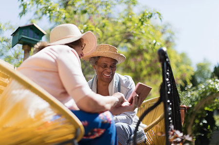 sending - Senior women friends using smart phone on sunny patio Photographie de stock - Premium Libres de Droits, Code: 6113-09192039