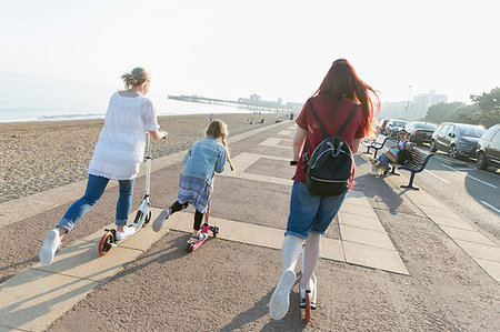 scooter rear view - Lesbian couple with daughter riding push scoters on sunny beach boardwalk Stock Photo - Premium Royalty-Free, Code: 6113-09199767