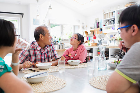 simsearch:6116-07235720,k - Multi-generation family eating noodles with chopsticks at table Stock Photo - Premium Royalty-Free, Code: 6113-09199899