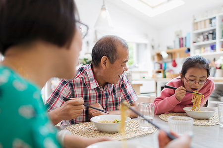simsearch:6116-07235720,k - Multi-generation family eating noodles with chopsticks at table Stock Photo - Premium Royalty-Free, Code: 6113-09199944