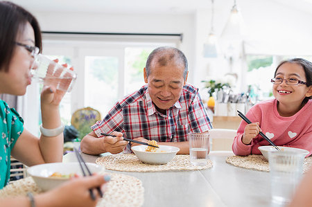 simsearch:6116-07235720,k - Multi-generation family eating noodles with chopsticks at table Stock Photo - Premium Royalty-Free, Code: 6113-09199945