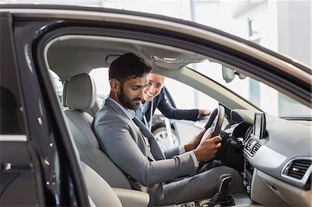 driver's seat - Car saleswoman and male customer in driver's seat of new car in car dealership showroom Stock Photo - Premium Royalty-Free, Code: 6113-09111763