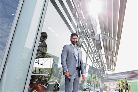 simsearch:6113-07542775,k - Portrait confident car salesman standing outside of car dealership showroom Stock Photo - Premium Royalty-Free, Code: 6113-09111764
