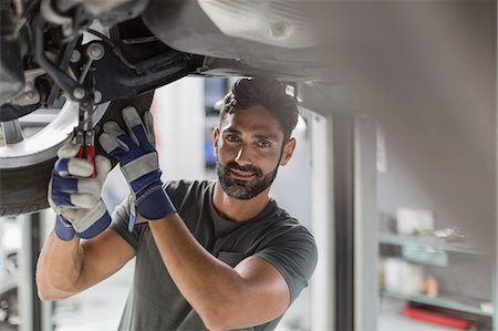 simsearch:6113-08722278,k - Portrait confident male auto mechanic working under car in auto repair shop Stock Photo - Premium Royalty-Free, Code: 6113-09111847
