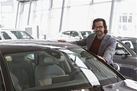 simsearch:649-07063808,k - Portrait smiling male customer shopping for new car in car dealership showroom Stock Photo - Premium Royalty-Free, Code: 6113-09111848