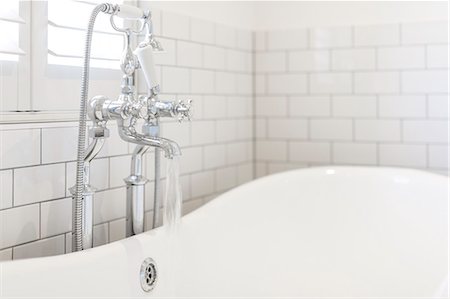 simsearch:6113-06898734,k - Water running from bathroom faucet into white soaking tub Photographie de stock - Premium Libres de Droits, Code: 6113-09111982