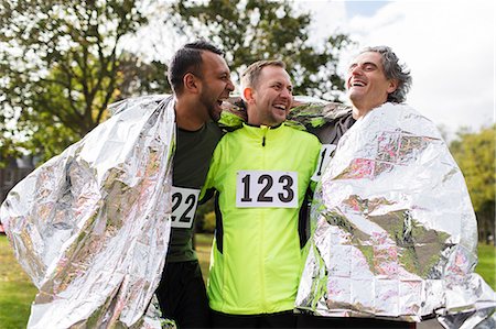 Happy male marathon runners wrapping in thermal blanket Stock Photo - Premium Royalty-Free, Code: 6113-09131247