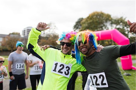 simsearch:693-07672615,k - Portrait playful male runners wearing wigs and cheering at charity run in park Stock Photo - Premium Royalty-Free, Code: 6113-09131219