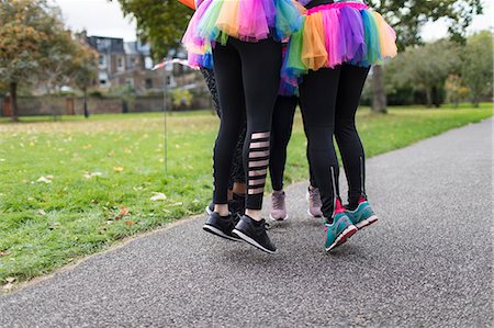 Enthusiastic female runners in tutus jumping on park path Stock Photo - Premium Royalty-Free, Code: 6113-09131346