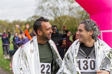 simsearch:693-07672615,k - Smiling male marathon runners wrapped in thermal blankets at finish line Stock Photo - Premium Royalty-Free, Code: 6113-09131372