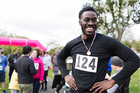simsearch:693-07672615,k - Portrait happy, confident male runner wearing medal at charity run in park Stock Photo - Premium Royalty-Free, Code: 6113-09131376