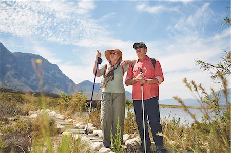 simsearch:693-06667816,k - Active senior couple hiking with hiking poles at sunny summer lakeside Stock Photo - Premium Royalty-Free, Code: 6113-09131475
