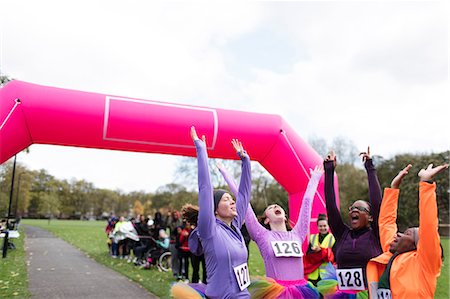 simsearch:6113-07648679,k - Enthusiastic female runners in tutus cheering, celebrating at charity run finish line Stock Photo - Premium Royalty-Free, Code: 6113-09131421