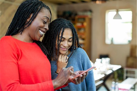 Mother and daughter using smart phone Stock Photo - Premium Royalty-Free, Code: 6113-09131577