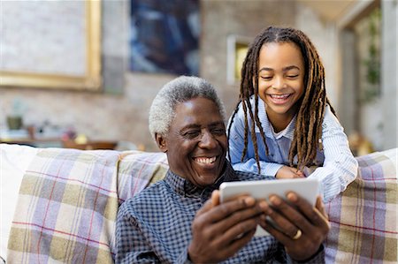 simsearch:6113-06908842,k - Happy grandfather and granddaughter using smart phone on sofa Stock Photo - Premium Royalty-Free, Code: 6113-09131591