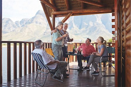 simsearch:649-07438003,k - Active senior couple toasting friends with wine glasses on lake cabin balcony Stock Photo - Premium Royalty-Free, Code: 6113-09131520