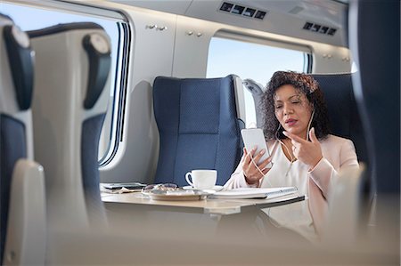 skype - Businesswoman video chatting with headphones and smart phone on passenger train Stock Photo - Premium Royalty-Free, Code: 6113-09131686