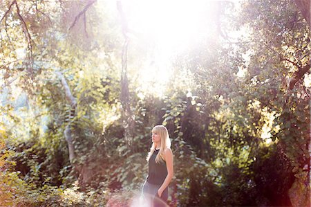 simsearch:649-08924209,k - Serene woman standing in sunny summer woods Stock Photo - Premium Royalty-Free, Code: 6113-09131693