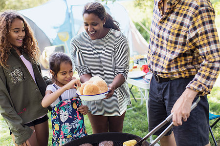 Family barbecuing hamburgers at campsite Stock Photo - Premium Royalty-Free, Code: 6113-09240047
