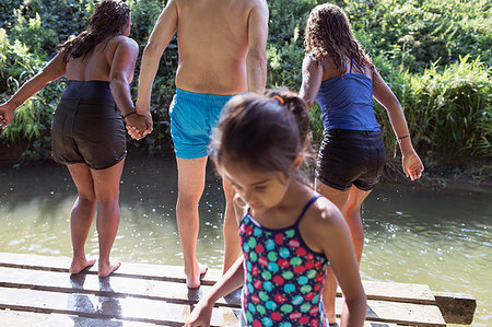 sister in a bathing suit - Family playing, jumping off dock into sunny river Stock Photo - Premium Royalty-Free, Code: 6113-09240050
