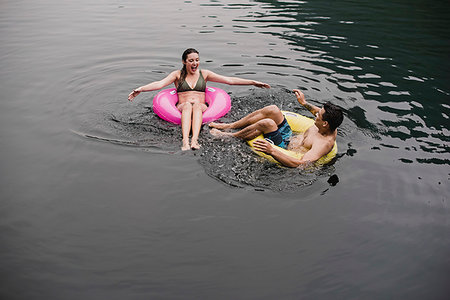 simsearch:6113-07147024,k - Young couple floating on lake in inflatable rings Stock Photo - Premium Royalty-Free, Code: 6113-09240141