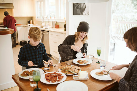 simsearch:695-03378605,k - Family eating breakfast at kitchen table Stock Photo - Premium Royalty-Free, Code: 6113-09240147