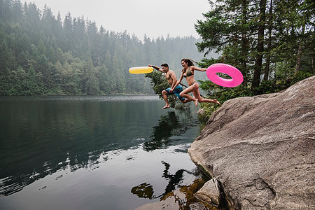 simsearch:6113-07147024,k - Playful young couple with inflatable rings jumping into remote lake, Squamish, British Columbia, Canada Stock Photo - Premium Royalty-Free, Code: 6113-09240126