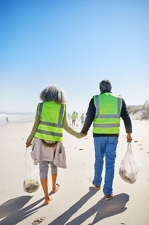 simsearch:859-06808649,k - Affectionate senior couple volunteers cleaning up litter on sunny, wet sand beach Stock Photo - Premium Royalty-Free, Code: 6113-09240258