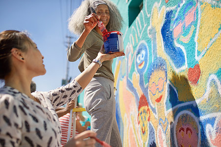 Female volunteers painting vibrant community mural on sunny urban wall Photographie de stock - Premium Libres de Droits, Code: 6113-09240276